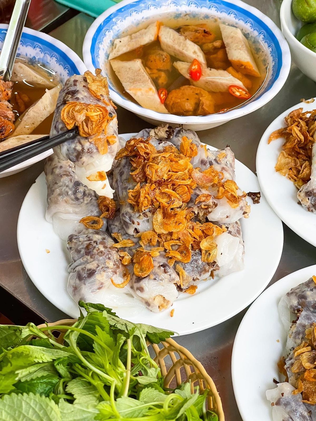 Le bánh cuốn est dégusté avec des herbes aromatiques et des échalotes frites croustillantes.