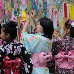 Des jeunes filles en yukata accrochent leurs vœux sur des branches de bambou lors du festival traditionnel.