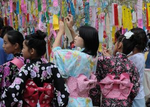 Des jeunes filles en yukata accrochent leurs vœux sur des branches de bambou lors du festival traditionnel.