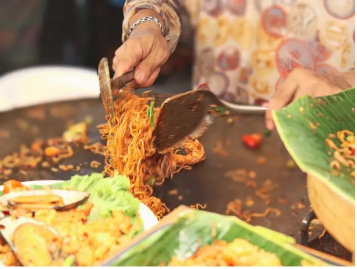 Un vendeur de rue prépare un plat thaïlandais à Bangkok.