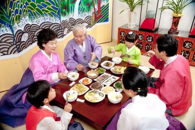 Everyone wears traditional clothing and gathers together to share a festive meal.