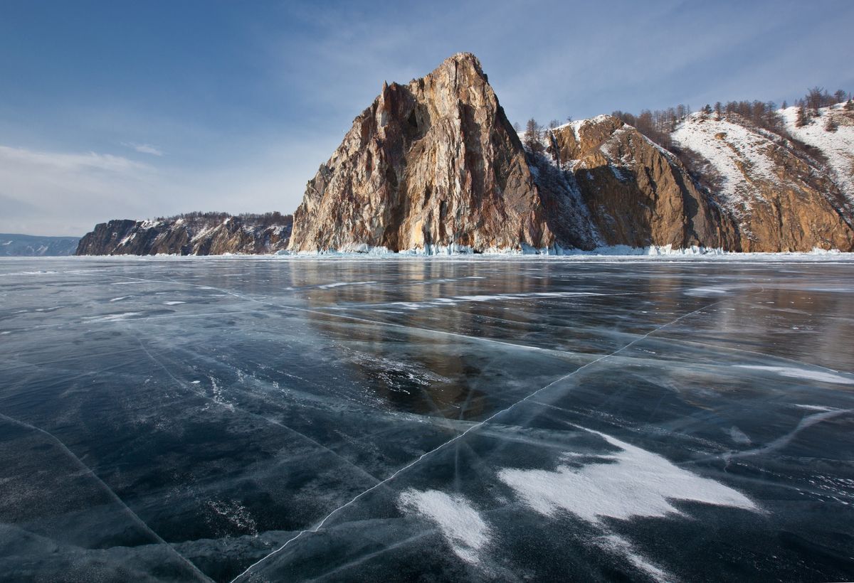 Baikal is covered in thick crystal-like ice, fractured into natural vein-like patterns
