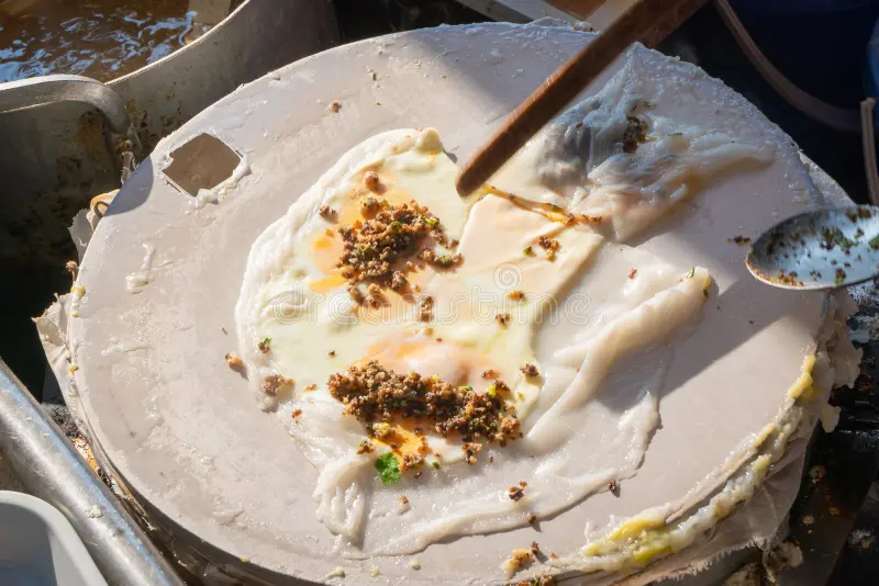 Banh cuon batter is spread thinly over a stretched cloth.